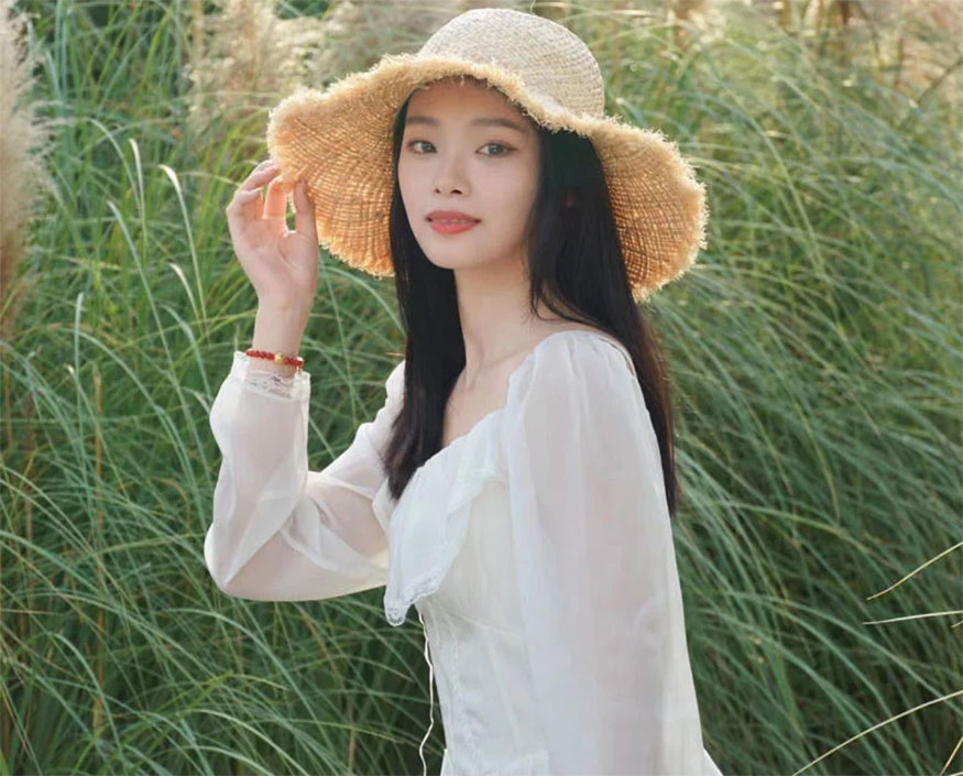 Đưa tay tạo dáng với mũ 